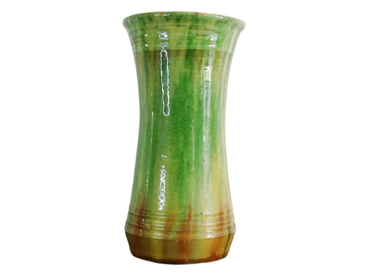 French antique pottery vase from the town of Castelnaudary. Glazed terracotta vase with a flared shape and glaze in shades of green, yellow, and earthy brown. Tall ceramic vase with dripping glaze effect for French countryside decor.