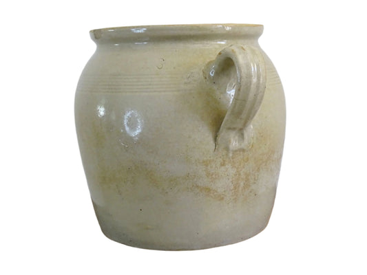French antique stoneware confit pot with beige glaze. Confit jar with two handles. Rustic farmhouse pottery pot or ceramic utensil holder.