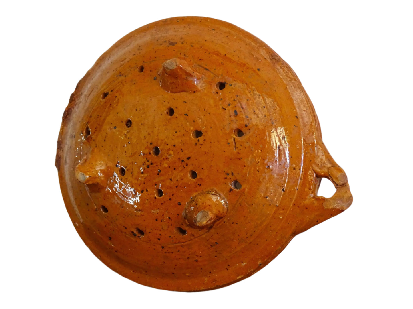 French antique terracotta sieve with orange glaze. Glazed pottery sieve on three pedestal feet. Rustic ceramic berry strainer for a farmhouse kitchen.