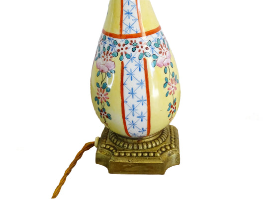 French vintage porcelain lamp base on a brass base. Ceramic table lamp with hand-painted in a Chinoiserie style, with floral motifs and geometric patterns on a yellow background. Ceramic vase lamp with slender, elongated form tapers to a flared top.