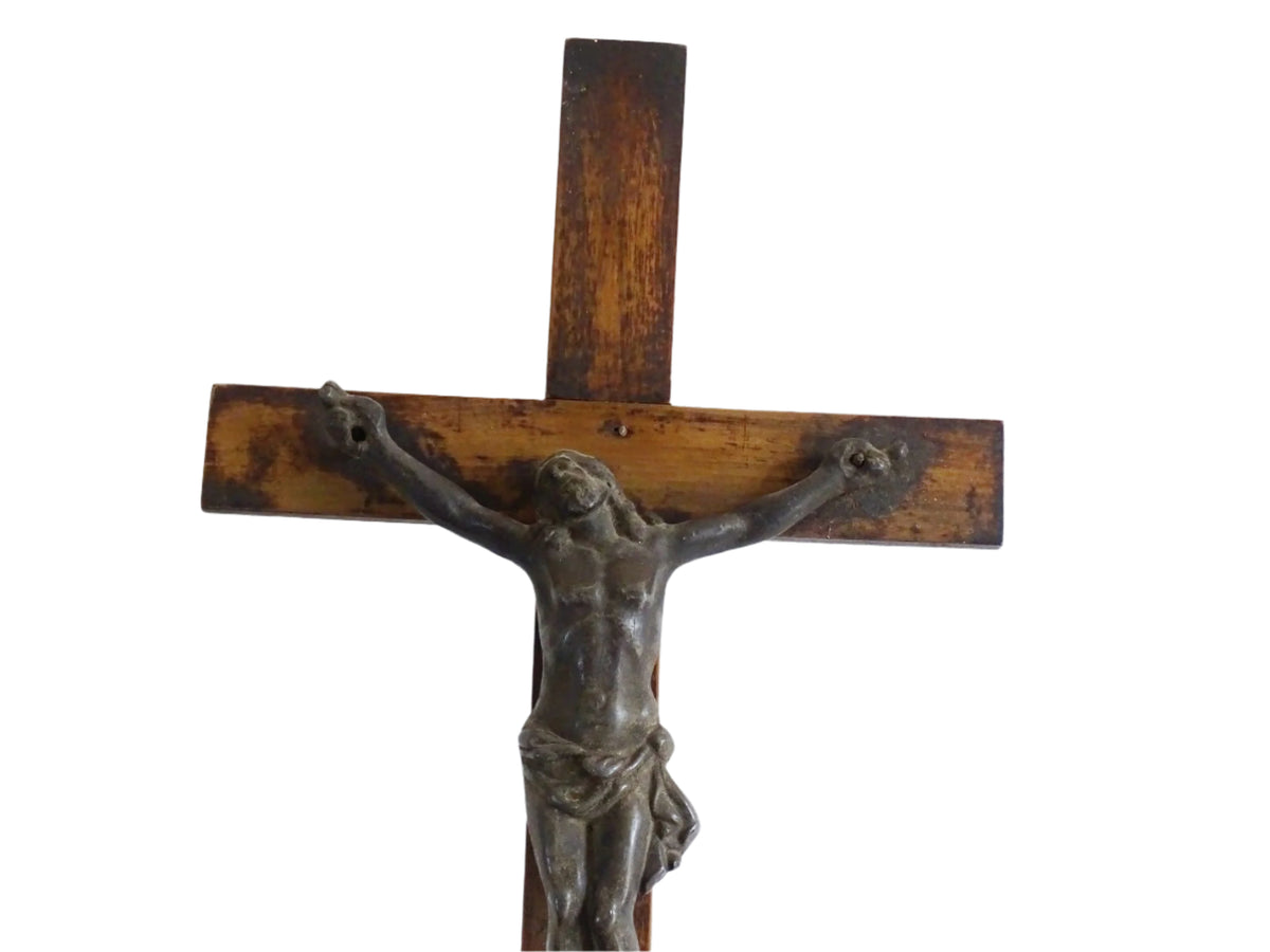 A French antique altar crucifix featuring a wooden cross with a spelter figure of Christ, mounted on a tiered wooden base. The wood has a rich patina.