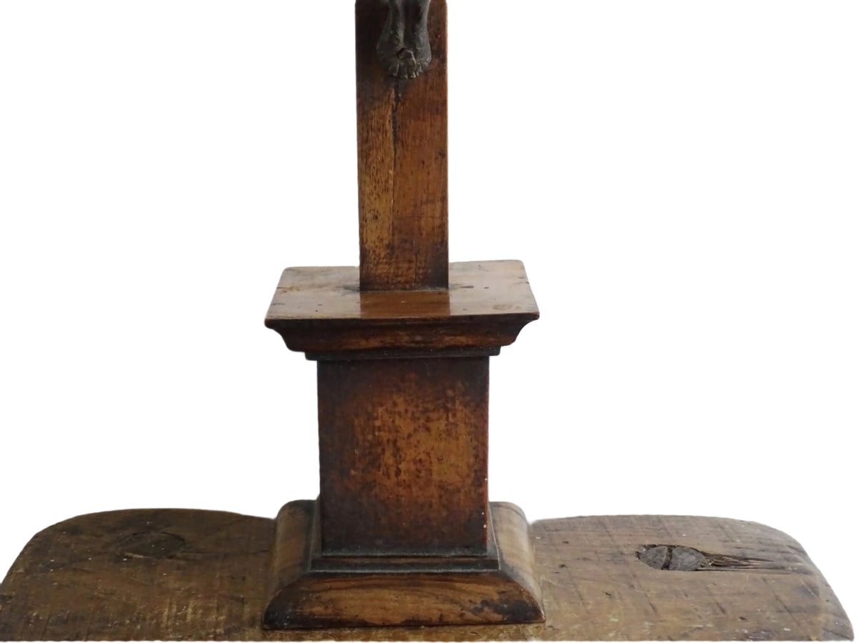 A French antique altar crucifix featuring a wooden cross with a spelter figure of Christ, mounted on a tiered wooden base. The wood has a rich patina.