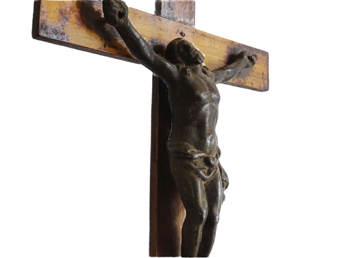 A French antique altar crucifix featuring a wooden cross with a spelter figure of Christ, mounted on a tiered wooden base. The wood has a rich patina.