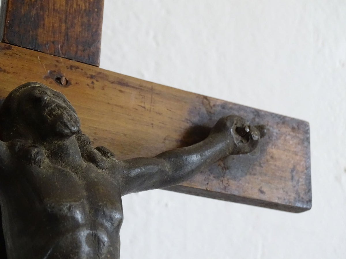 A French antique altar crucifix featuring a wooden cross with a spelter figure of Christ, mounted on a tiered wooden base. The wood has a rich patina.