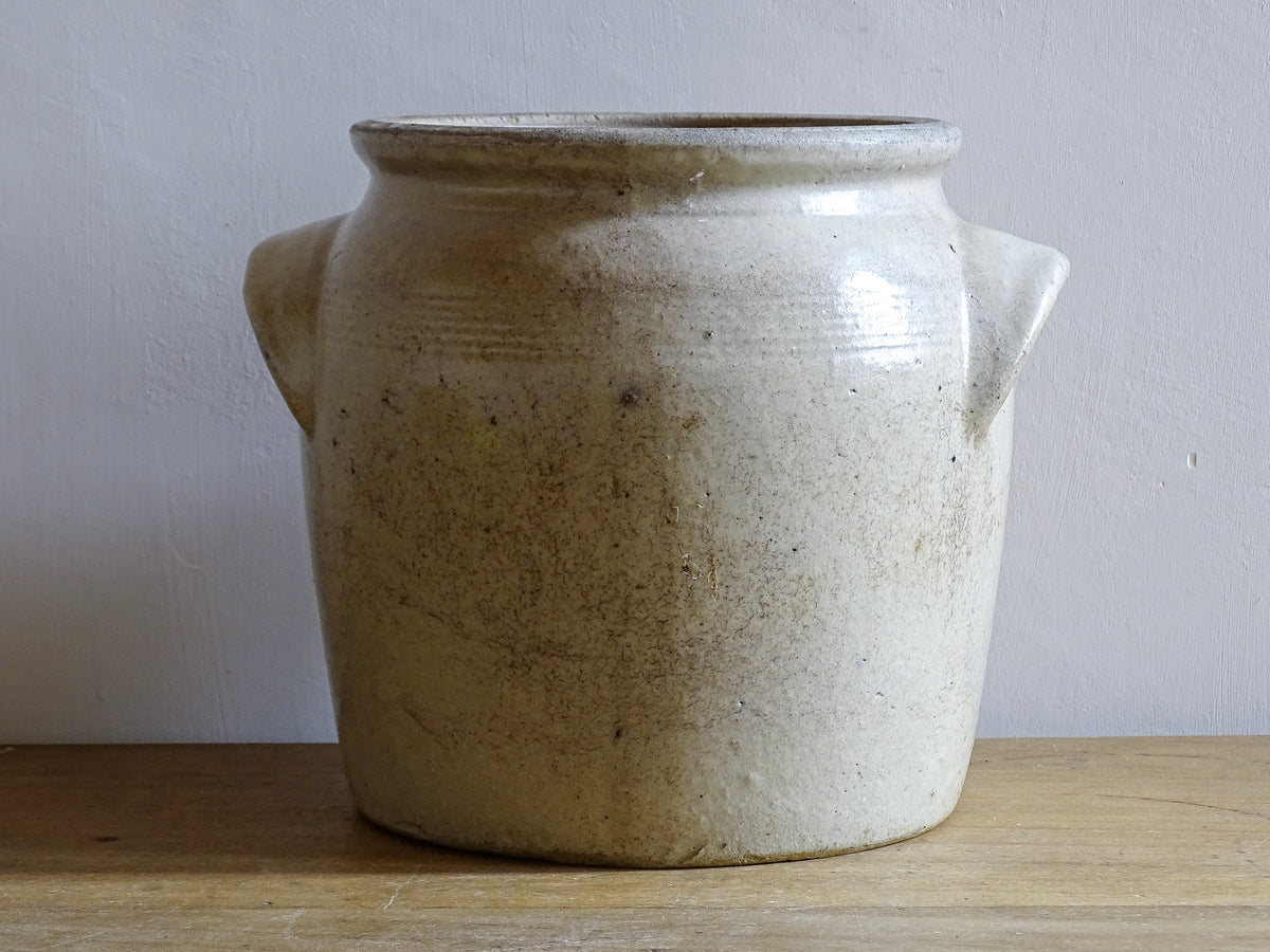 Rustic French antique stoneware confit jar. Glazed pottery cache pot is in a grey beige glaze for a French farmhouse style home.