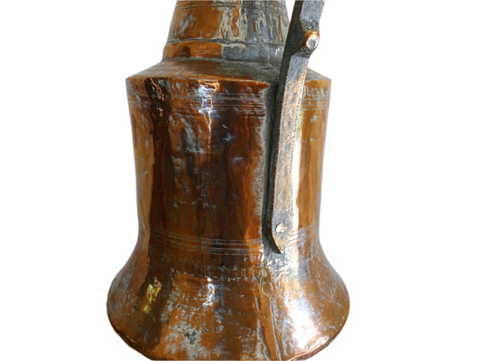 French antique copper pitcher converted into a copper table lamp. The antique lamp has a flared base, curved handle, and surface patina.