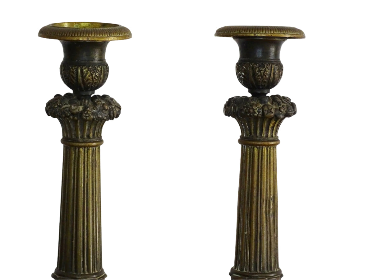 French antique bronze candle holders. French restoration period candlesticks are on a tripod base with lion paw feet and acanthus leaves. Acanthus leaves and various fruits and berries adorn the top of the reeded columns.