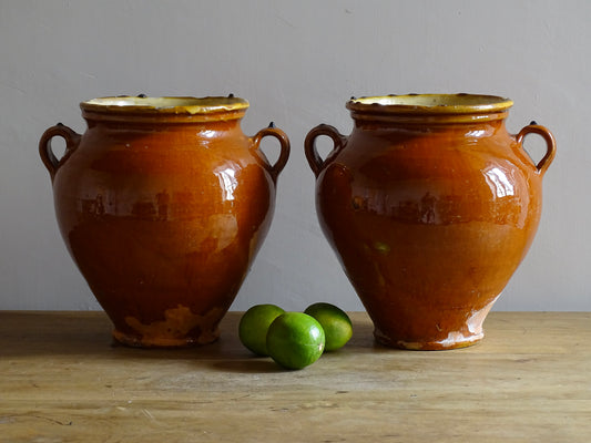 Pair of French antique confit pot vases with an orange glaze to the exterior and a yellow glaze to the interior for preserving food. Ceramic jars for rustic farmhouse decor. Orange and yellow glazed terracotta vases.