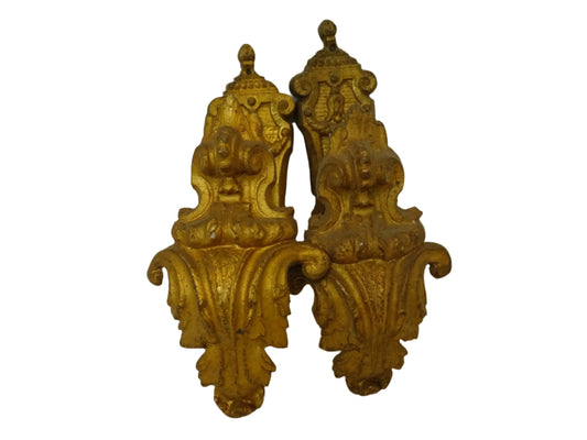 Pair of French antique curtain holdbacks in gilt bronze. These rococo style hooks are adorned with acanthus leaf motifs.