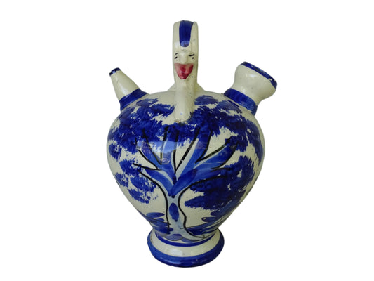 Spanish vintage blue and white ceramic gargoulette. This pottery water pitcher is hand-painted with trees and the figure of an animal. It has a handle to the top with faces to each side, as well as two spouts.