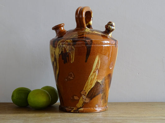 Rustic Catalan antique pottery gargoulette with a jaspé glaze in yellow or brown. The body of this marble glazed terracotta water jug has a sturdy handle to the top and two spouts.