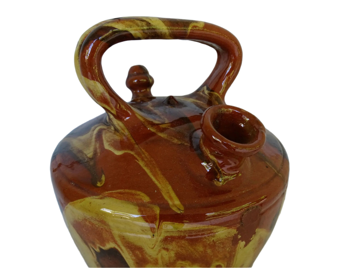 Rustic Catalan antique pottery gargoulette with a jaspé glaze in yellow or brown. The body of this marble glazed terracotta water jug has a sturdy handle to the top and two spouts.