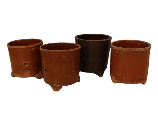 Set of four French antique terracotta faisselles or cheese strainers. Rustic earthenware pots with three feet.