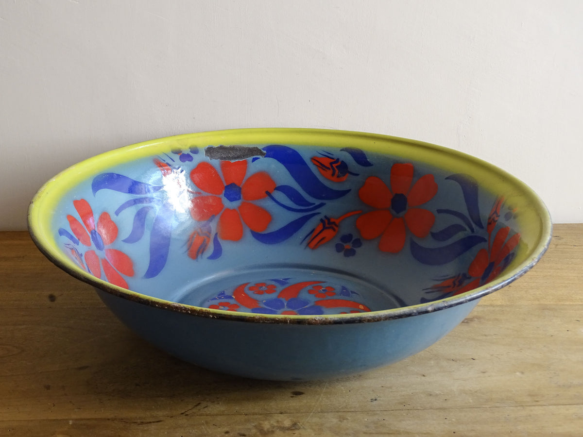 French vintage enamelled bowl with blue background, red flowers and a yellow trim.