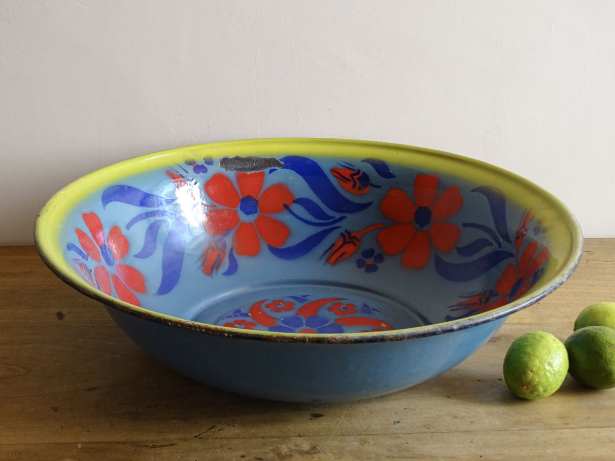 French vintage enamelled bowl with blue background, red flowers and a yellow trim.