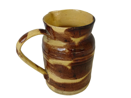 Antique French pottery jug with a yellow glaze and brown drip glaze detailing. This Dieulefit ceramic pitcher has a handle to the side. Rustic French farmhouse aesthetic.