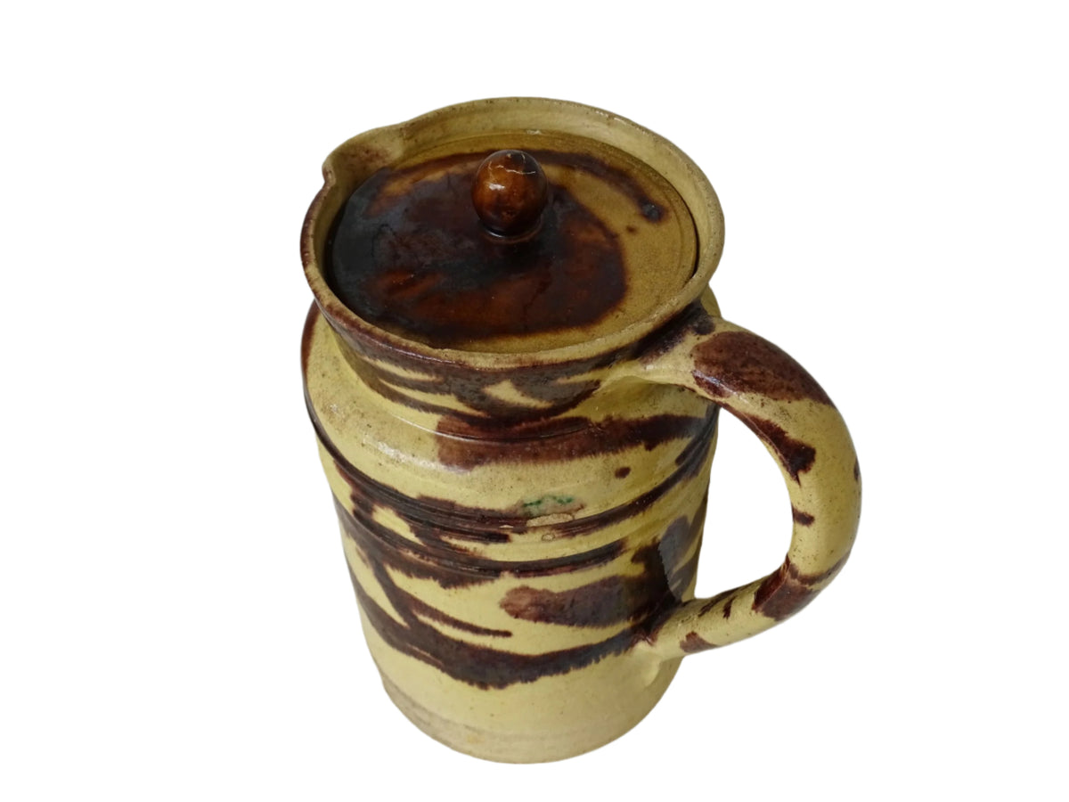 Large French antique ceramic pitcher with a lid. The glazed pottery jug has a gorgeous brown drip glaze on a yellow glazed background.