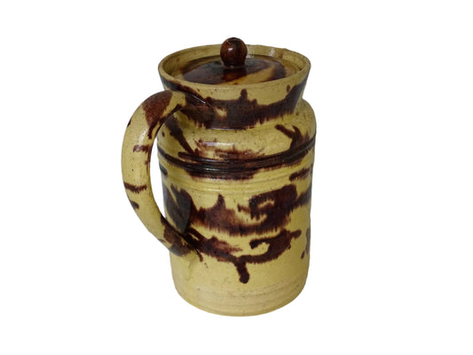 Large French antique ceramic pitcher with a lid. The glazed pottery jug has a gorgeous brown drip glaze on a yellow glazed background.