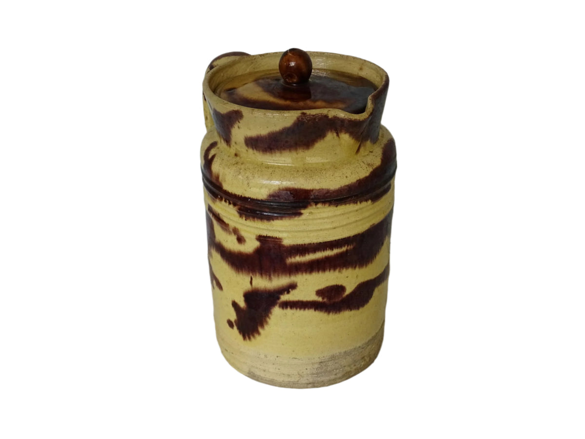Large French antique ceramic pitcher with a lid. The glazed pottery jug has a gorgeous brown drip glaze on a yellow glazed background.