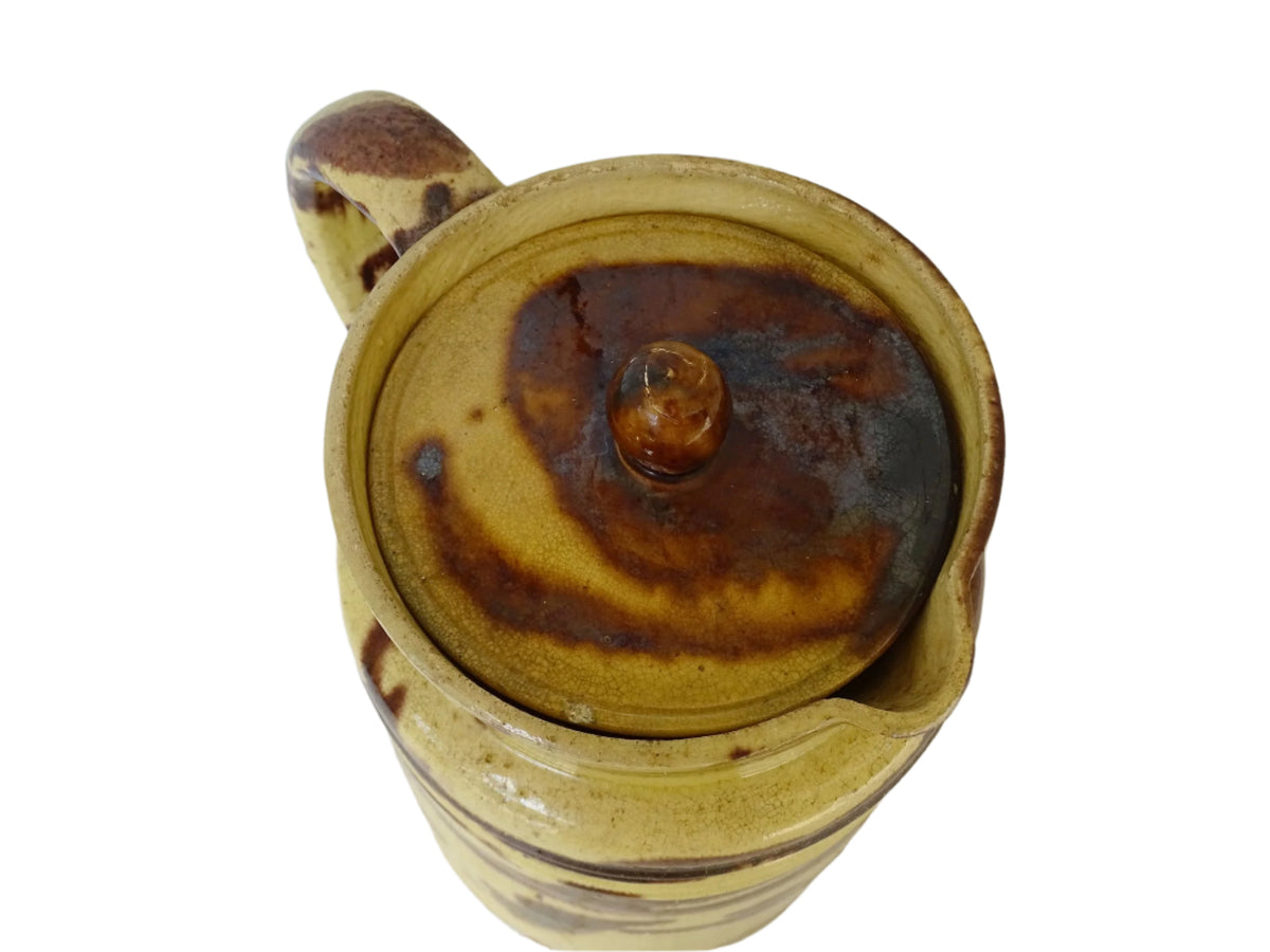 Large French antique ceramic pitcher with a lid. The glazed pottery jug has a gorgeous brown drip glaze on a yellow glazed background.