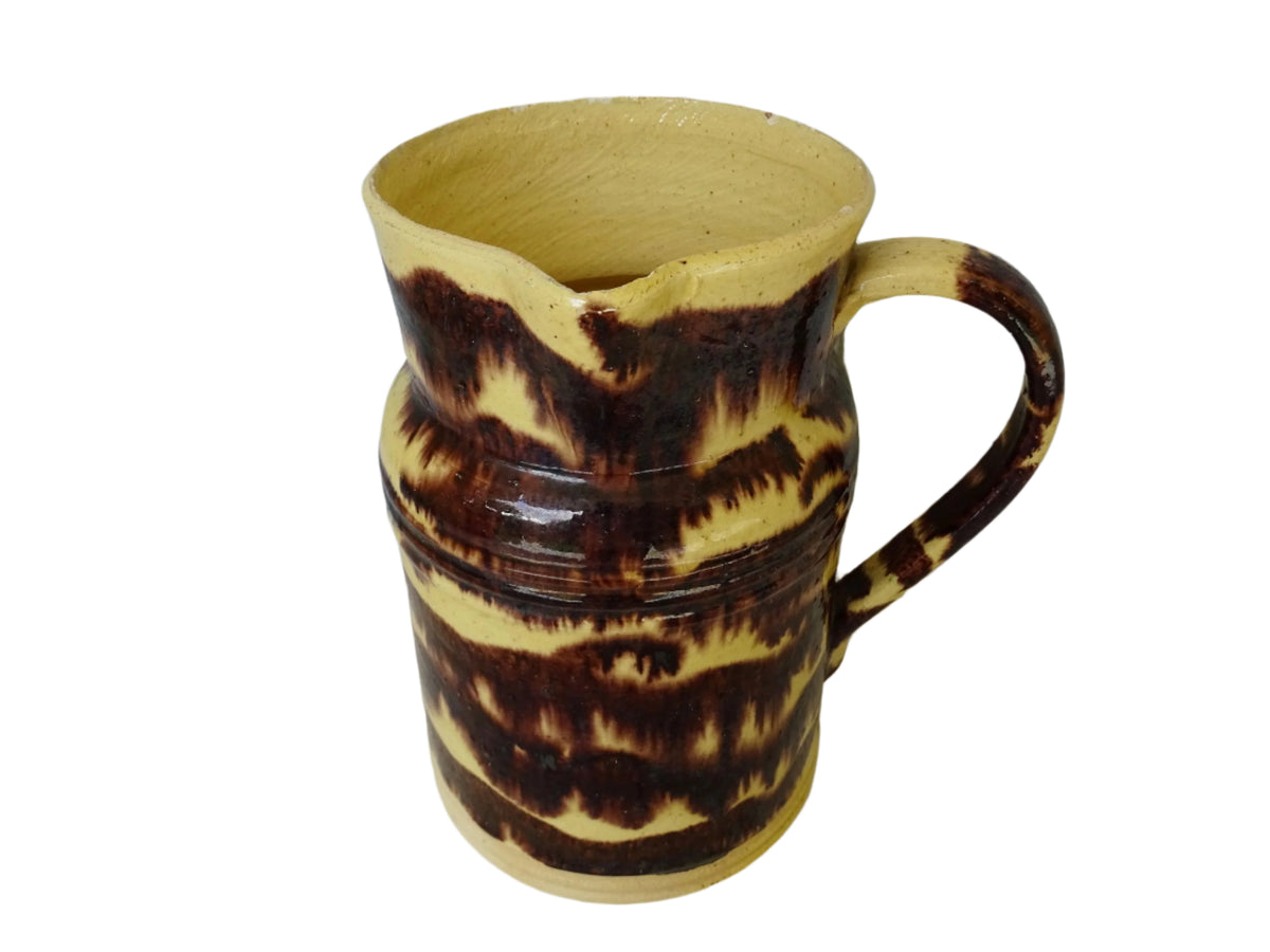 Rustic French antique ceramic pitcher with yellow glaze and brown drip glaze detailing. This Dieulefit pottery jug has a handle to the side.
