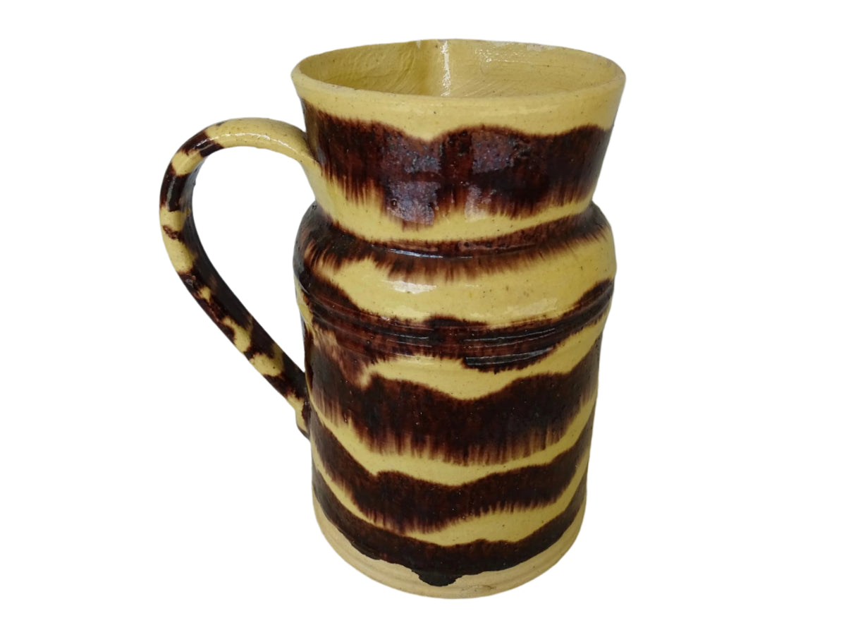 Rustic French antique ceramic pitcher with yellow glaze and brown drip glaze detailing. This Dieulefit pottery jug has a handle to the side.