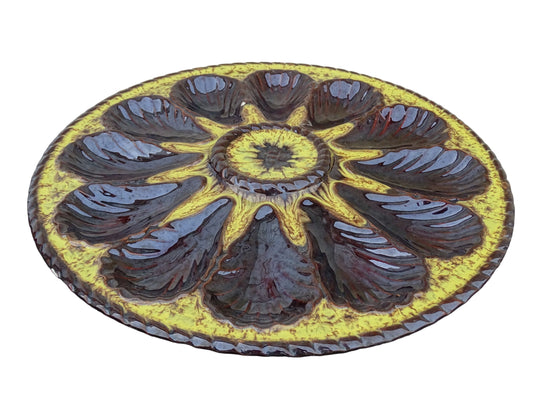 Large French vintage Vallauris pottery oyster plate by Maruis Giuge with space for twelve oysters. It has a yellow and brown glaze.