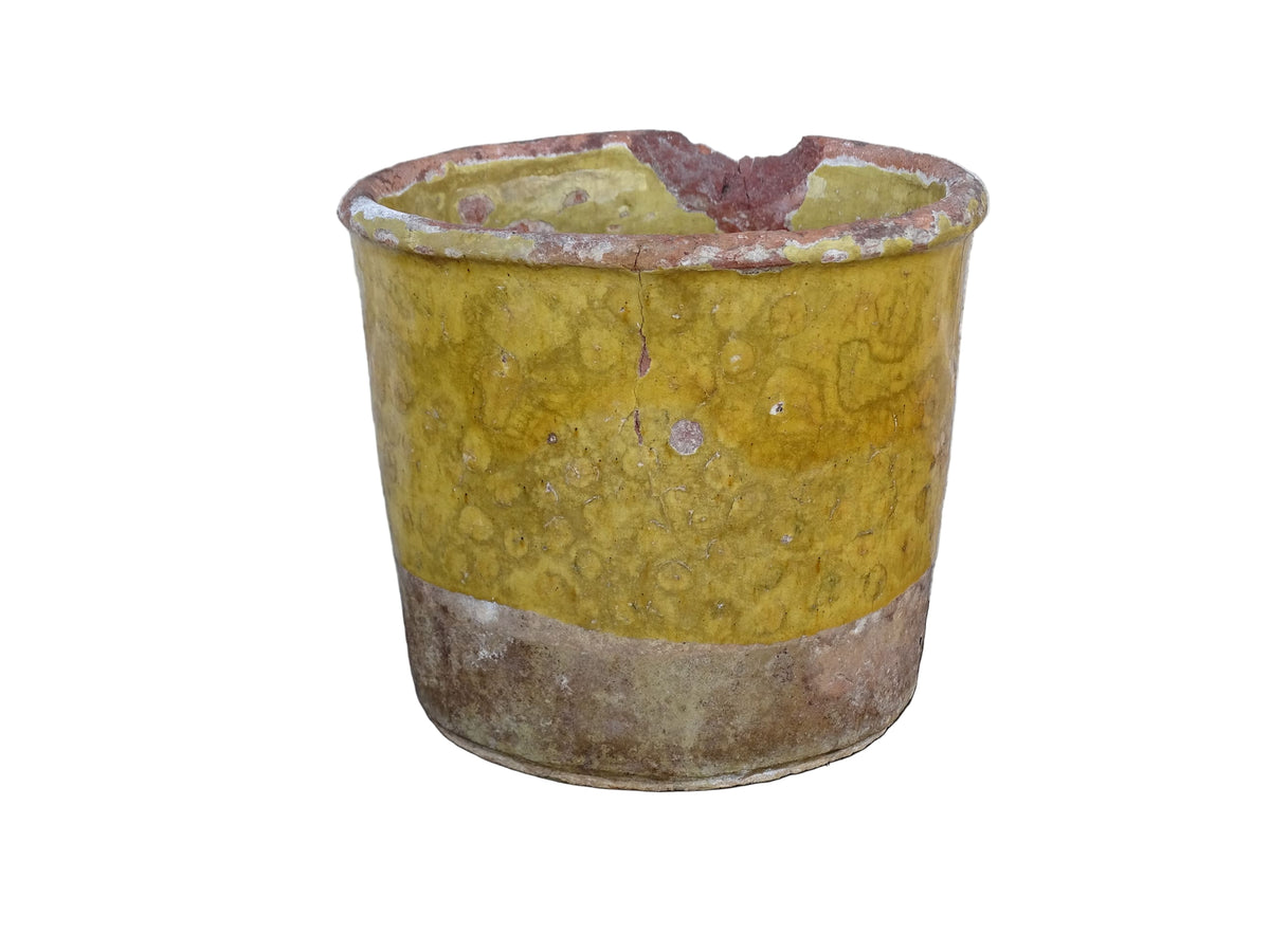 French antique yellow confit pot with patina. Aged earthenware pot with glaze.