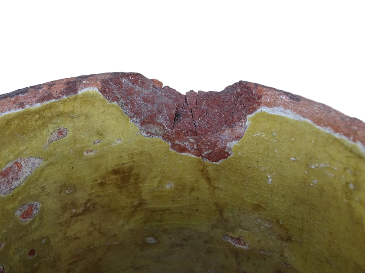 French antique yellow confit pot with patina. Aged earthenware pot with glaze.