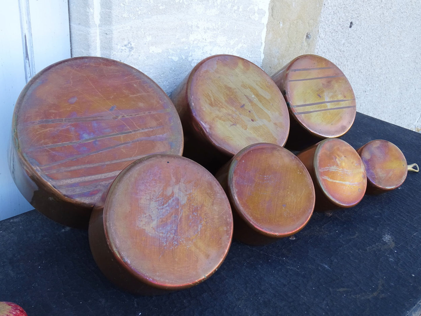 Set of seven French antique copper pans with brass handles. Tinned copper saucepans.