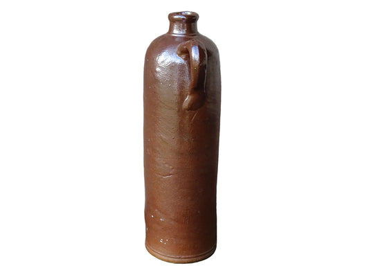 Antique salt glazed stoneware bottle, with a raised lion medallion on the shoulder and a loop handle. Bottle with textured surface and deep brown glaze.