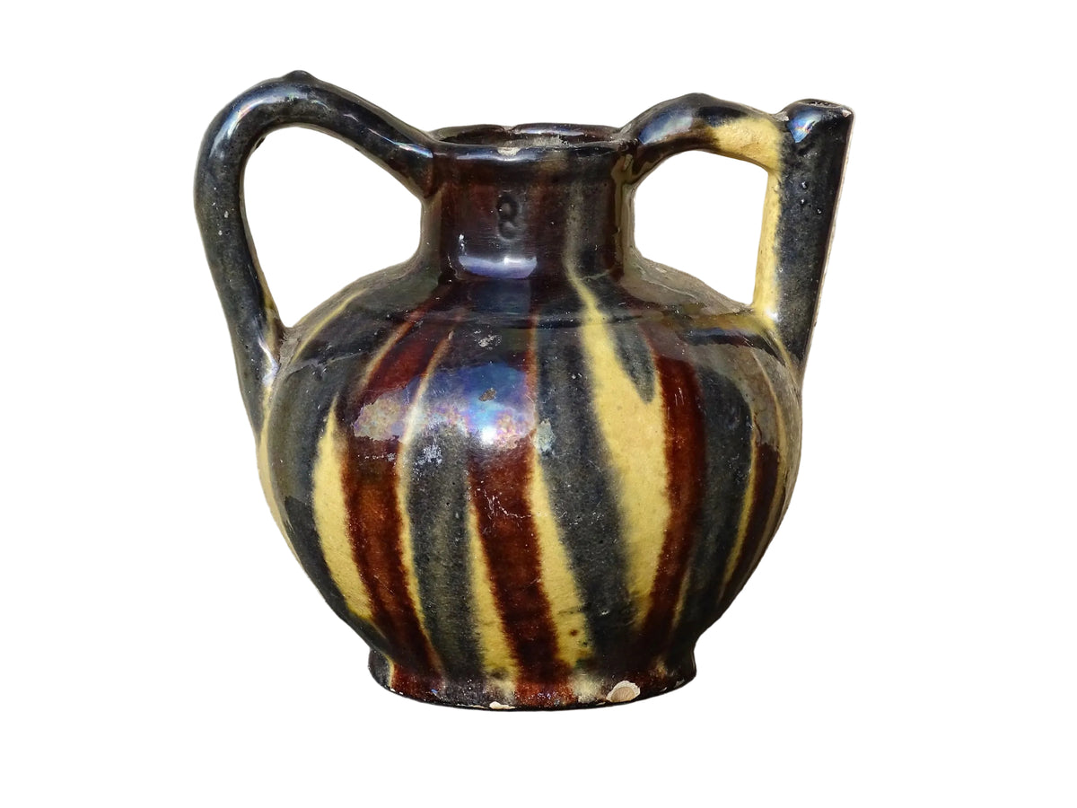 French antique ceramic jug or orjol with striped glaze. Glazed terracotta pitcher with yellow, black and brown glaze.