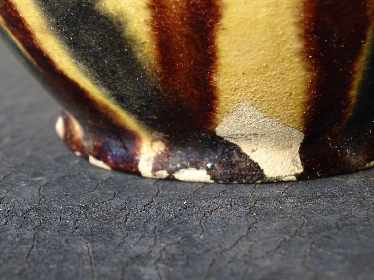French antique ceramic jug or orjol with striped glaze. Glazed terracotta pitcher with yellow, black and brown glaze.