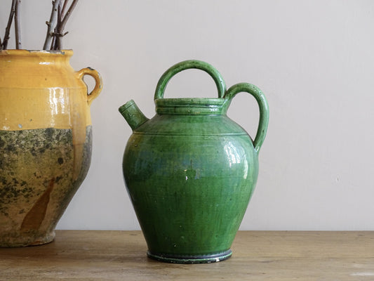 French antique gargoulette with green glaze from Provence. This antique Provençal water pitcher has a spout and two handles with a vivid green glaze. Pottery cruche.