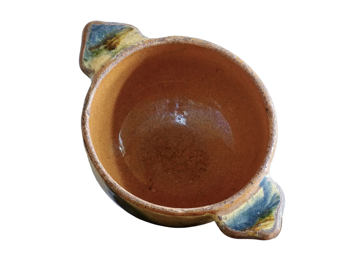 A French vintage ceramic souvenir bowl from Vichy, in the Auvergne region of France. Decorated with hand-applied sponged slip in yellow, green and blue tones. Mid 20th century, with a warm rustic glaze and visible age-related crazing.