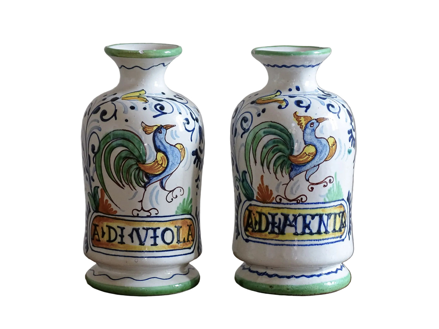 A pair of Italian Antique pharmacy jars dating to circa 1920. These tin-glazed, earthenware jars are decorative in the Renaissance revival tradition. They are painted with colourful cockerels and scrolling foliage.