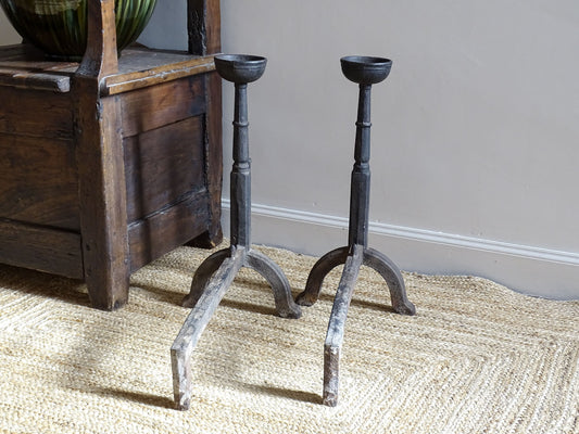 A pair of French antique cast iron andirons or fire dogs, date to the 19th century. They are large and heavy and each have two spit hooks to the front and bowls to the top.