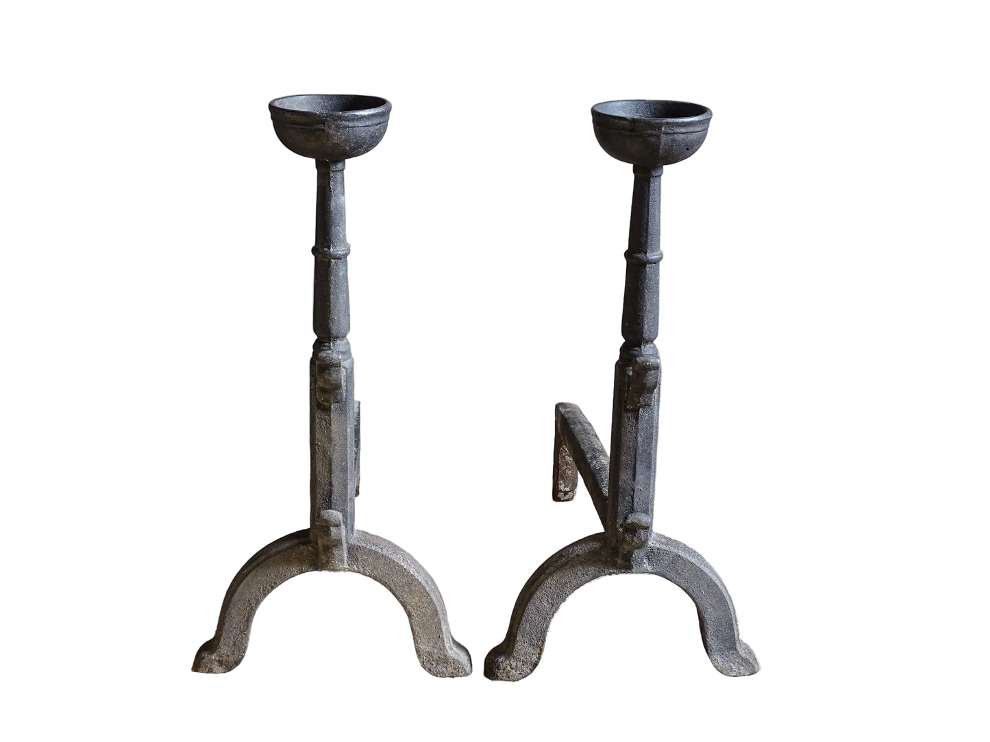 A pair of French antique cast iron andirons or fire dogs, date to the 19th century. They are large and heavy and each have two spit hooks to the front and bowls to the top.