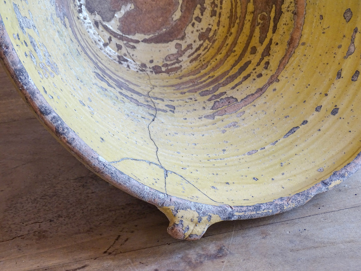 Large antique French confit bowl or gressalle with a yellow glaze to the inside and an unglazed exterior. This terracotta bowl, also known as a tian bowl, has a beautiful patina and originates from South West France.