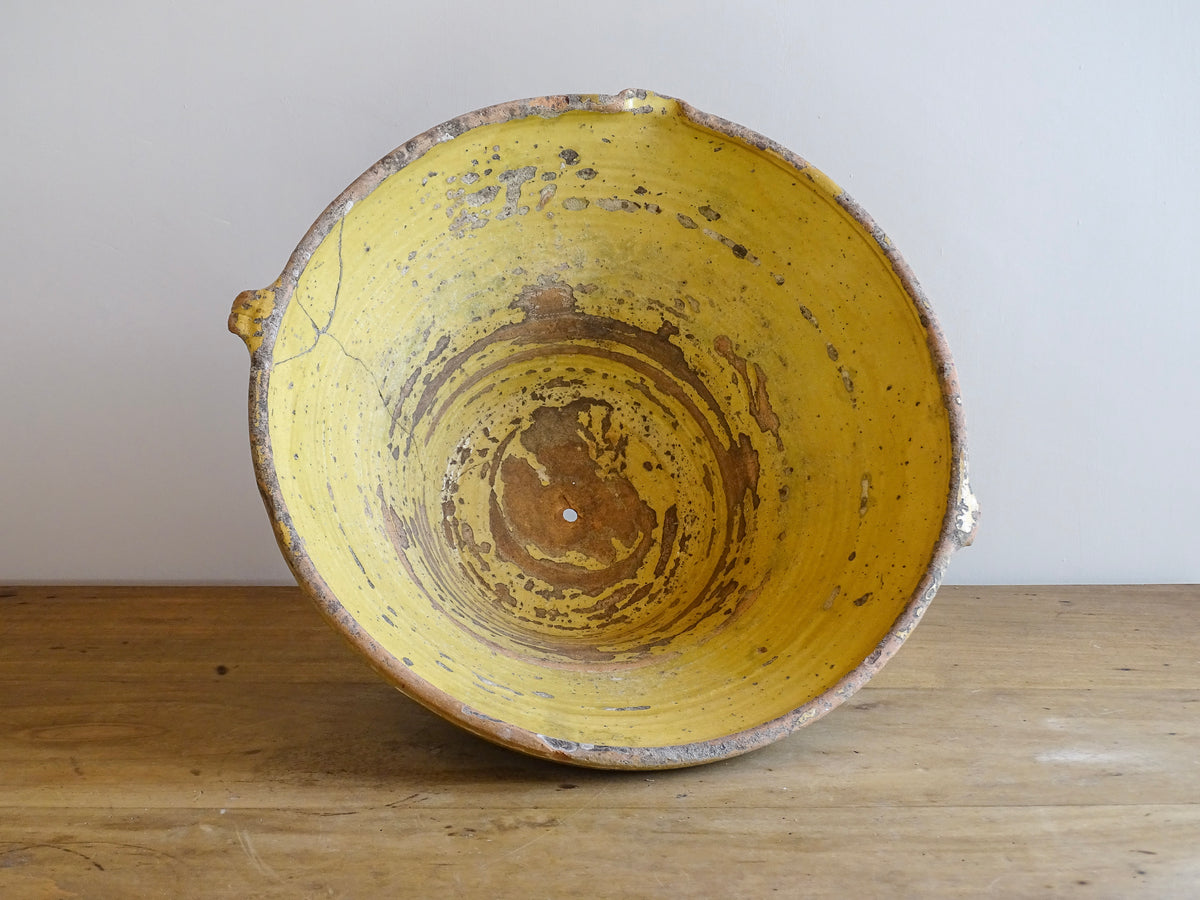 Large antique French confit bowl or gressalle with a yellow glaze to the inside and an unglazed exterior. This terracotta bowl, also known as a tian bowl, has a beautiful patina and originates from South West France.