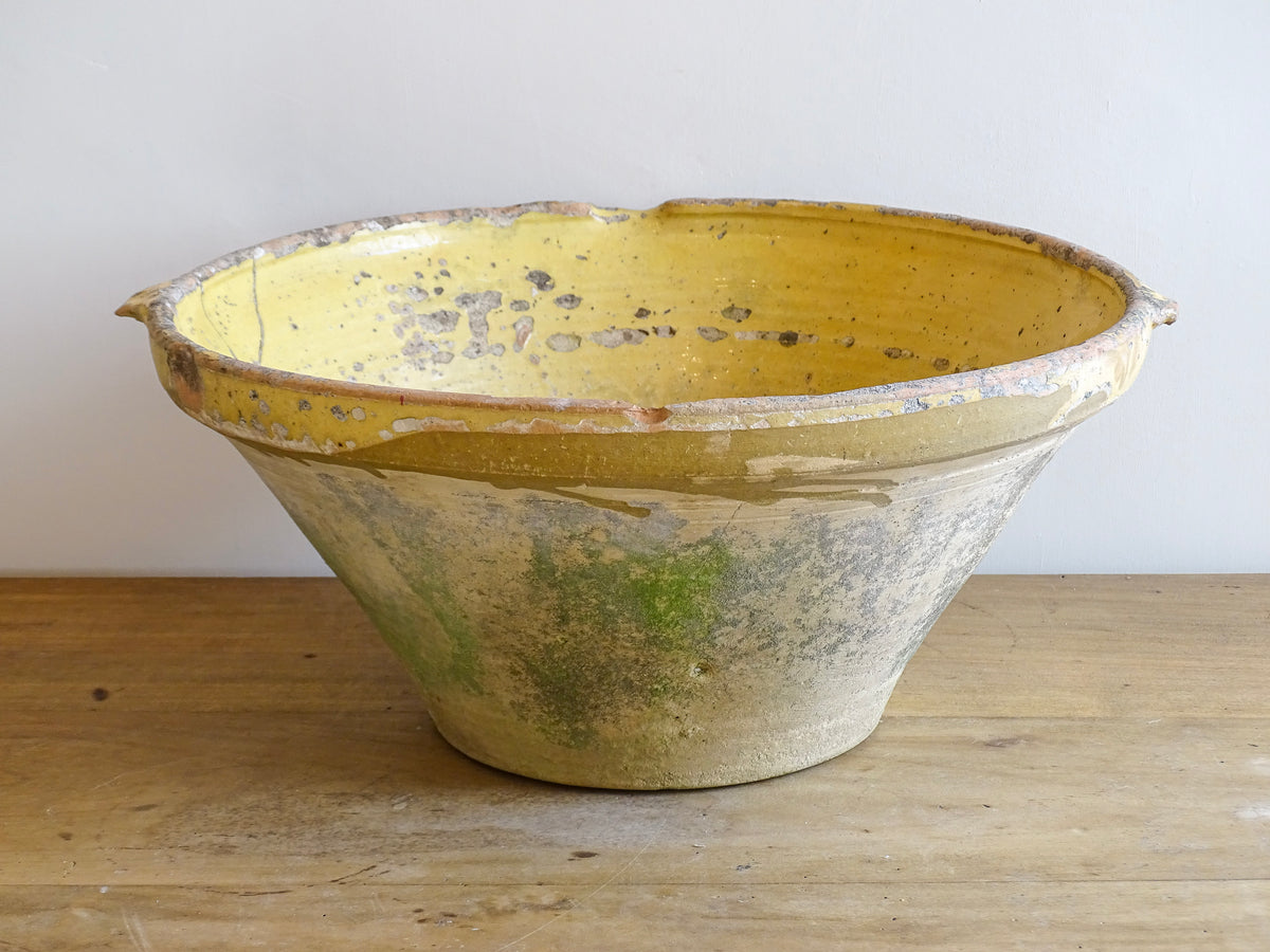 Large antique French confit bowl or gressalle with a yellow glaze to the inside and an unglazed exterior. This terracotta bowl, also known as a tian bowl, has a beautiful patina and originates from South West France.