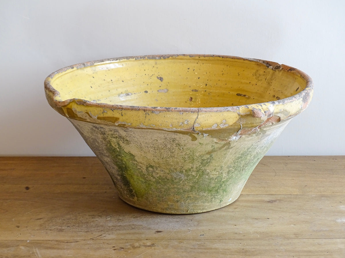 Large antique French confit bowl or gressalle with a yellow glaze to the inside and an unglazed exterior. This terracotta bowl, also known as a tian bowl, has a beautiful patina and originates from South West France.