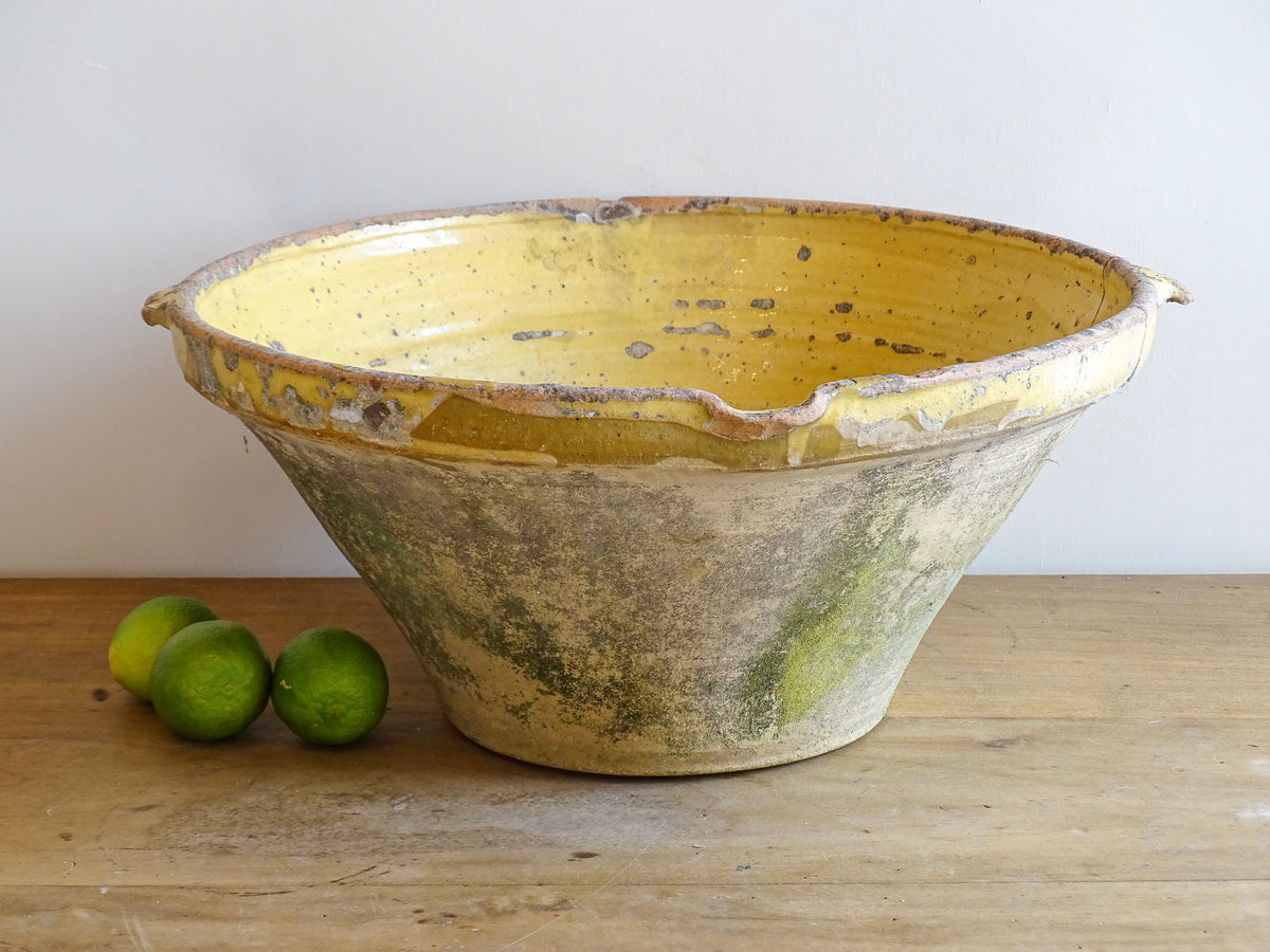 Large antique French confit bowl or gressalle with a yellow glaze to the inside and an unglazed exterior. This terracotta bowl, also known as a tian bowl, has a beautiful patina and originates from South West France.