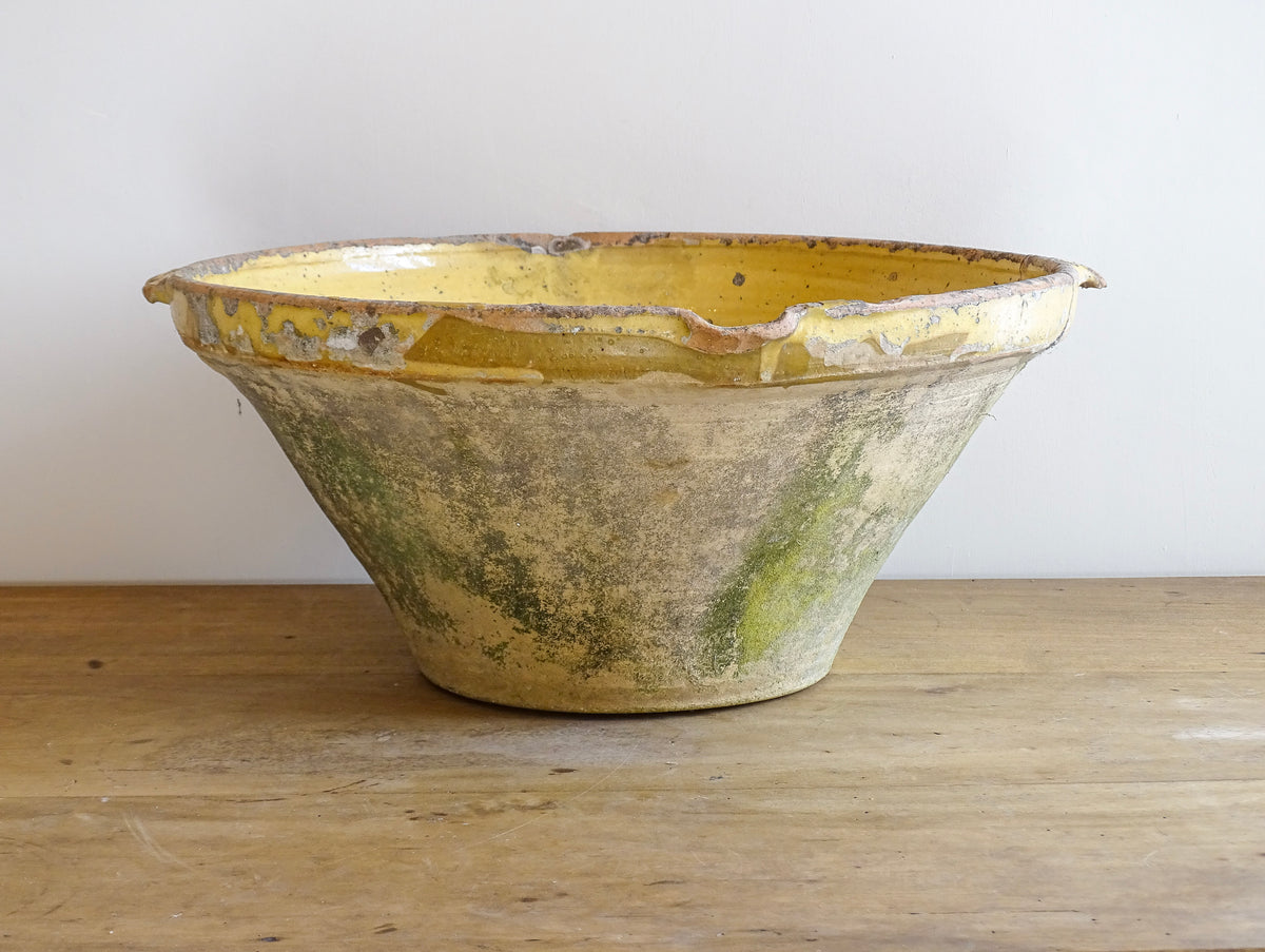 Large antique French confit bowl or gressalle with a yellow glaze to the inside and an unglazed exterior. This terracotta bowl, also known as a tian bowl, has a beautiful patina and originates from South West France.