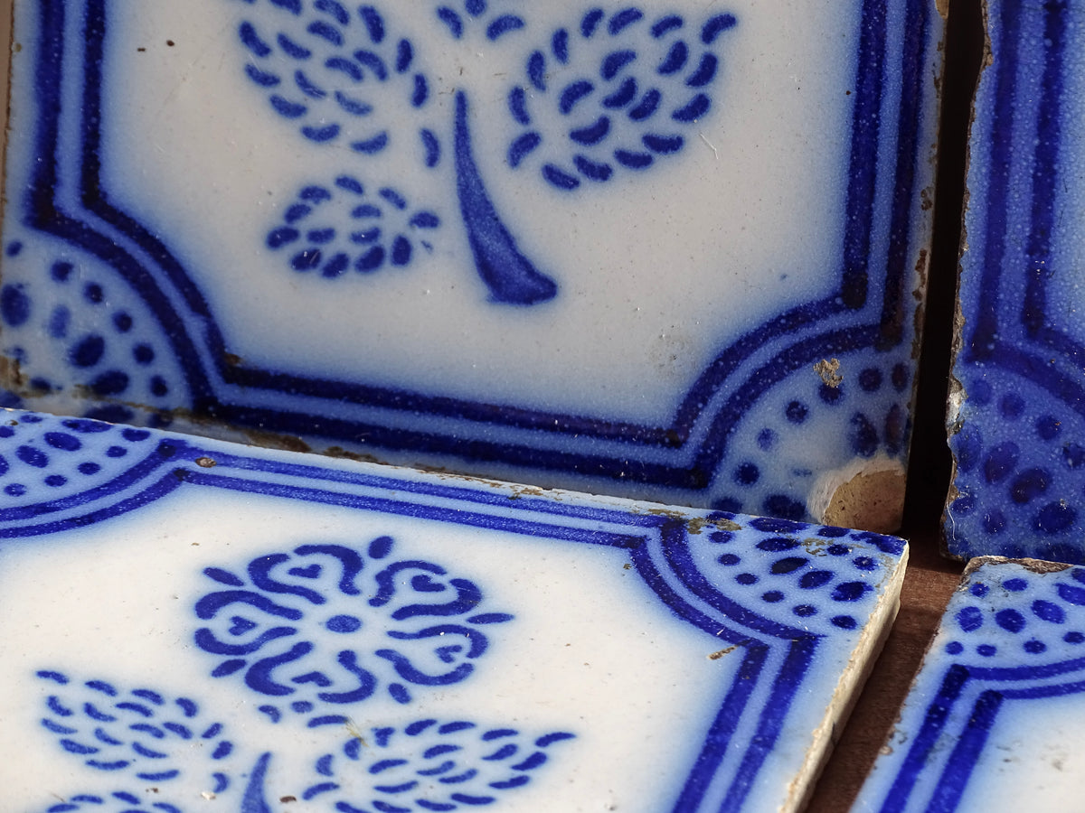 A set of eight French antique Desvres faience tiles in blue & white. These transfer printed, earthenware tiles were manufactured in the late 1900's in Desvres, Northern France. Six of the tiles are back-stamped. They are beautifully transfer printed in cobalt blue. A floral sprig sits in the centre of the cartouche framing.