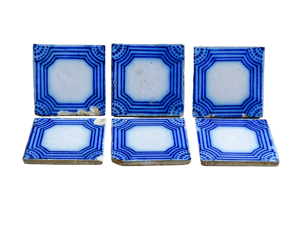 A set of six French antique Desvres faience tiles in blue & white. These transfer printed, earthenware tiles were manufactured in the late 1900's in Desvres, Northern France. Five of the tiles are back-stamped. They are beautiful, transfer printed, architectural blue and white faience tiles with layered cobalt blue cartouche framing.