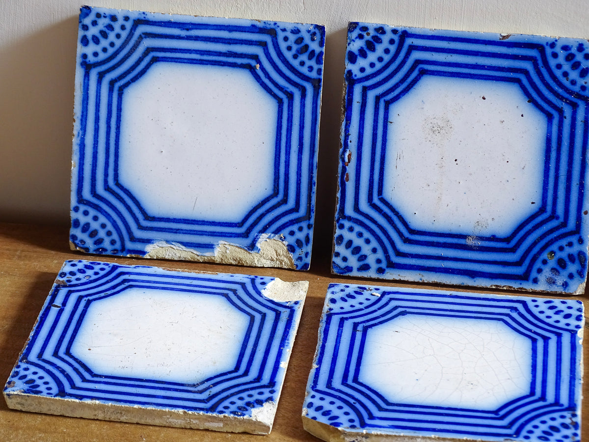 A set of six French antique Desvres faience tiles in blue & white. These transfer printed, earthenware tiles were manufactured in the late 1900's in Desvres, Northern France. Five of the tiles are back-stamped. They are beautiful, transfer printed, architectural blue and white faience tiles with layered cobalt blue cartouche framing.
