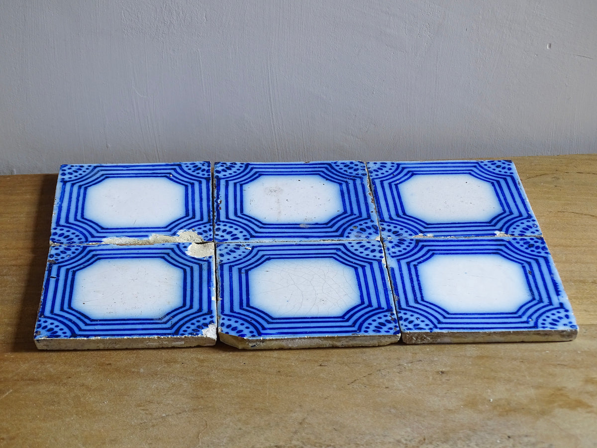 A set of six French antique Desvres faience tiles in blue & white. These transfer printed, earthenware tiles were manufactured in the late 1900's in Desvres, Northern France. Five of the tiles are back-stamped. They are beautiful, transfer printed, architectural blue and white faience tiles with layered cobalt blue cartouche framing.