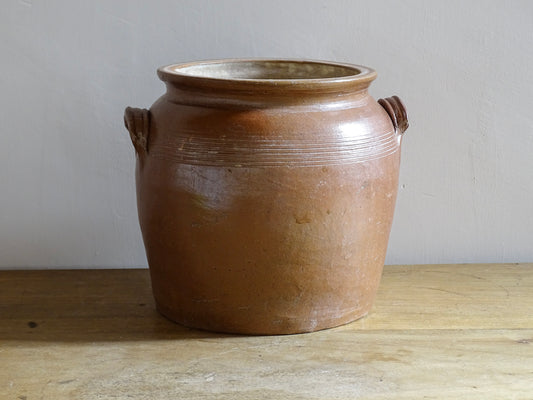 A French antique stoneware confit pot with a brown glaze. This is a salt glazed pottery cache pot. It dates to the early 20th century and would look amazing as part of a rustic French farmhouse style home.