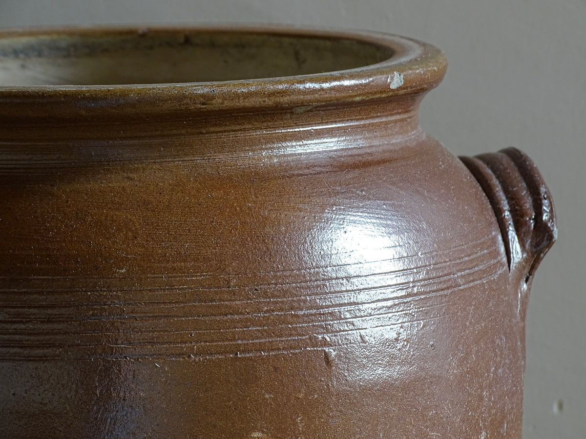 A French antique stoneware confit pot with a brown glaze. This is a salt glazed pottery cache pot. It dates to the early 20th century and would look amazing as part of a rustic French farmhouse style home.